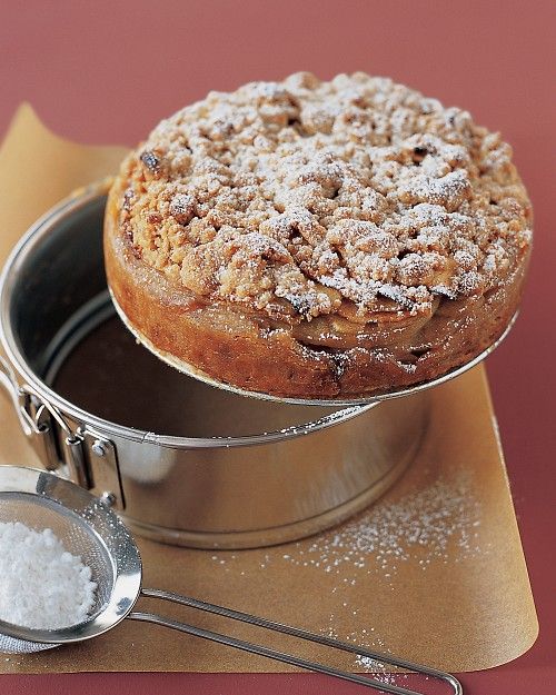 a cake sitting on top of a metal pan next to a scoop of powdered sugar