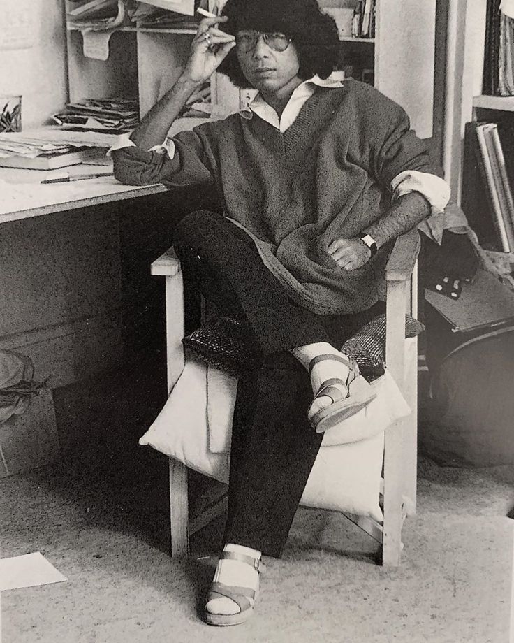 a black and white photo of a person sitting at a desk