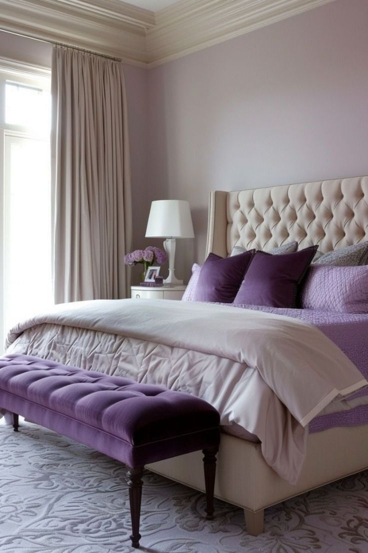 a bedroom with purple walls and white bedding, an upholstered headboard