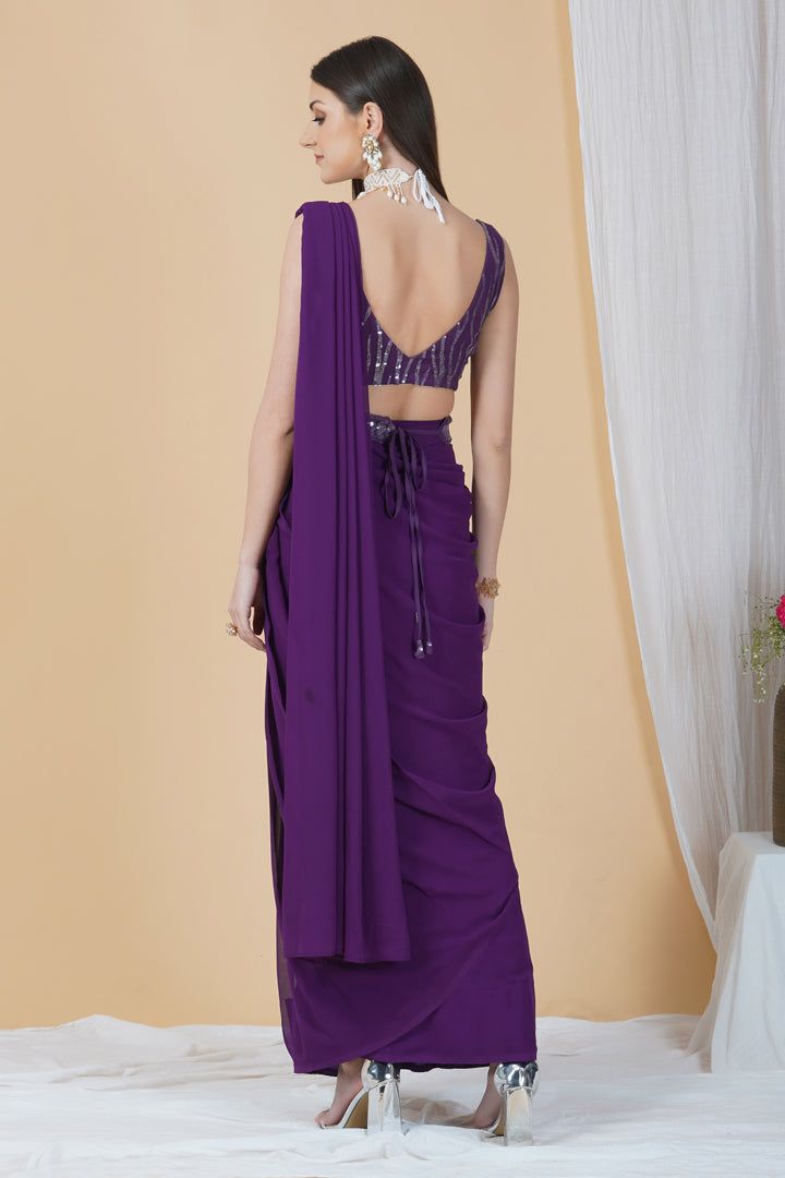 Get ready to leave everyone awestruck with your grace by adorning this ready to wear saree in a dreamy purple hue. With a belt running across and a tie-knot at back, this saree can be perfectly worn for an engagement or a cocktail party.Style Ready to Wear Saree with an embellished belt Dreamy Purple hue Sequins blouse Georgette fabric Specifications Model height - 5'9" Model wearing - S Elegant Purple Pre-draped Saree, Purple Embellished Pre-draped Saree, Embellished Purple Pre-draped Saree, Purple Embellished Georgette Pre-draped Saree, Purple Floor-length Pre-draped Saree For Reception, Purple Georgette Pre-draped Saree For Evening, Elegant Purple Choli With Traditional Drape, Traditional Purple Pre-draped Saree For Party, Purple Bollywood Party Pre-draped Saree