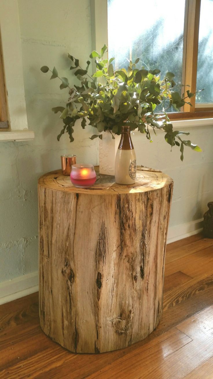 a wooden table with a vase and candle on it