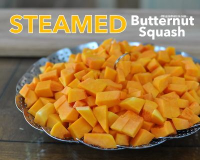 a plate full of cut butternut squash on a wooden table with the title steamed butternut squash