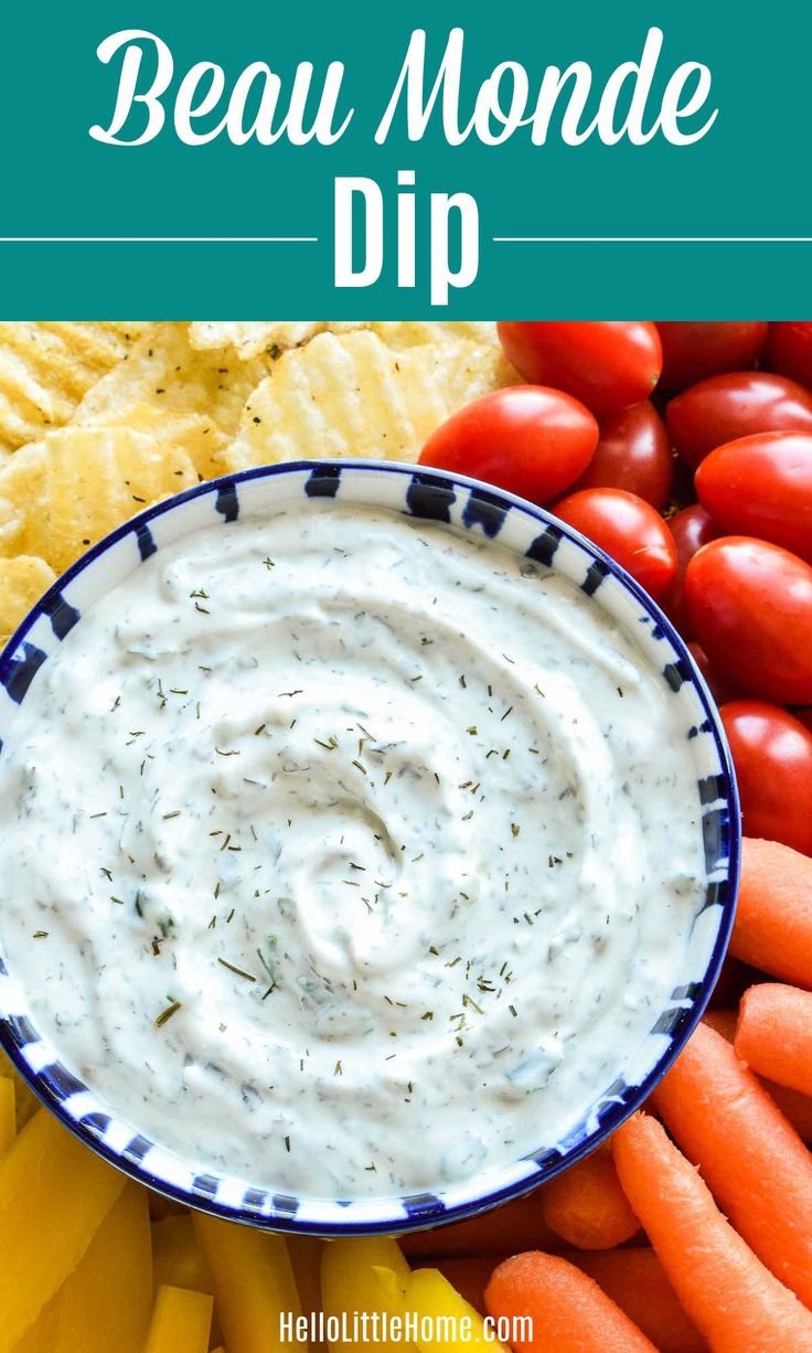 a bowl filled with ranch dip surrounded by carrots and chips