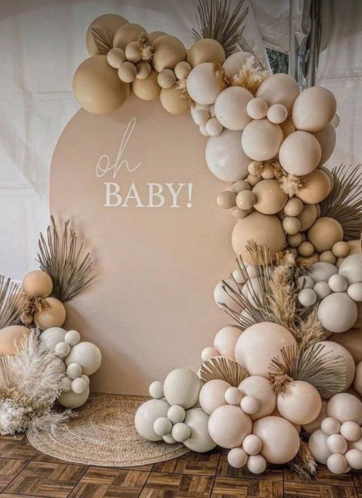 a baby shower is decorated with balloons and palm leaves on the wall, along with other decorations