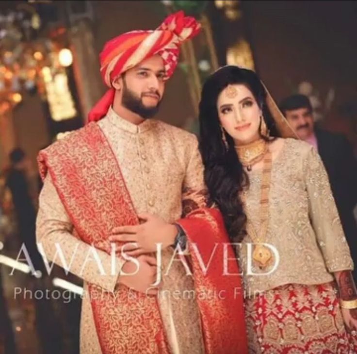 two people standing next to each other wearing red and gold outfits