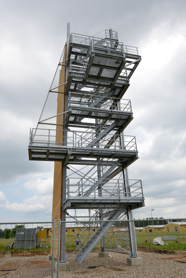 a tall metal structure sitting on top of a dirt field