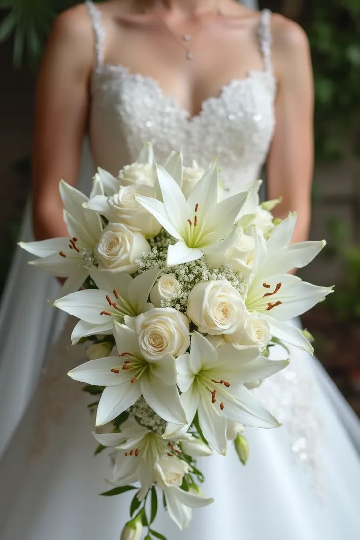 a bride holding a bouquet of white flowers