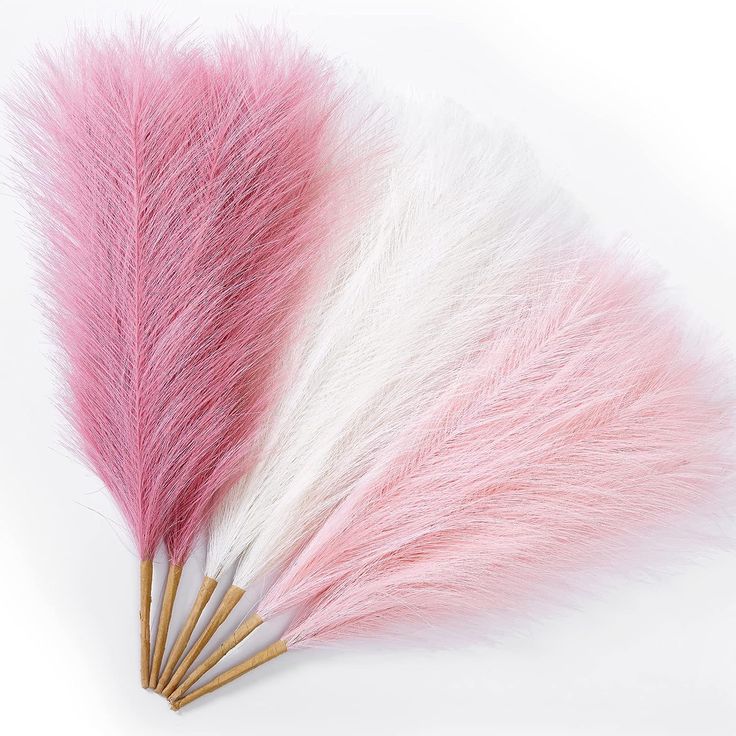 three pink and white feathers on top of each other