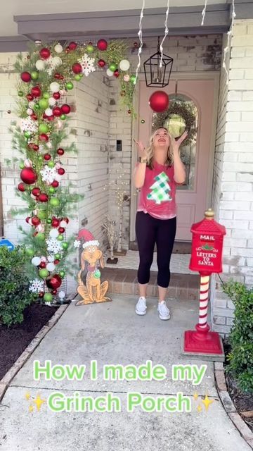 a woman standing in front of a house with christmas decorations