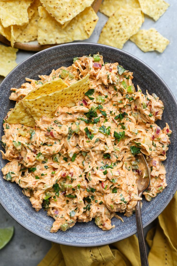 a bowl filled with guacamole and chips next to some tortilla chips