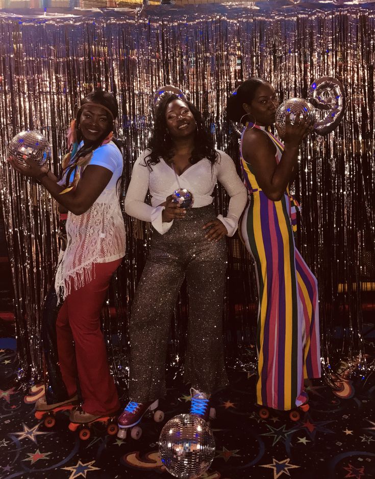 three women standing next to each other holding bubbles