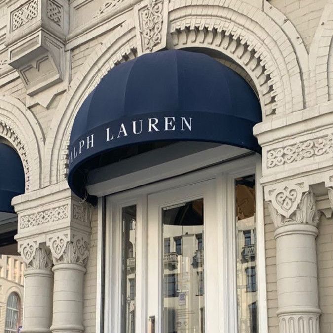 the front entrance to an old building with blue awnings and white trimming