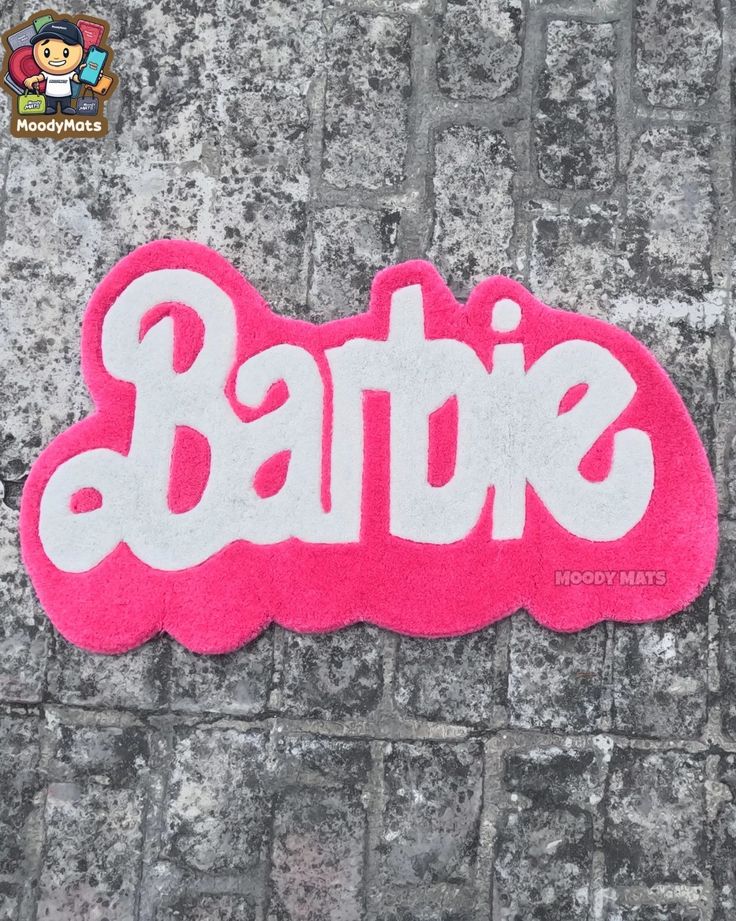 a pink sticker that says batte on the side of a brick wall with white letters