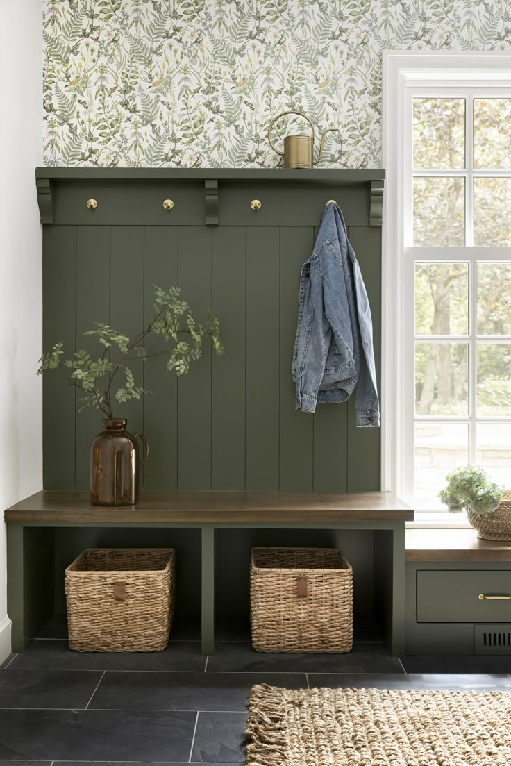 a bench with two baskets underneath it and a coat rack on the wall next to it