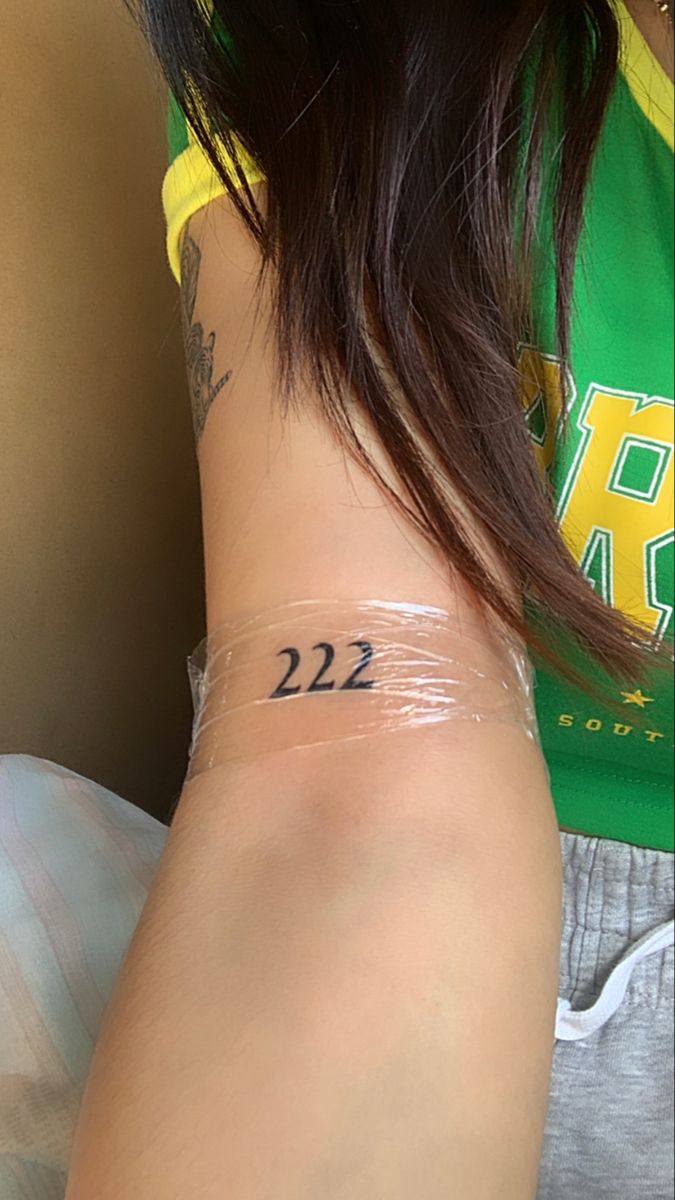 a woman with a tattoo on her arm and the number 22 is written on it