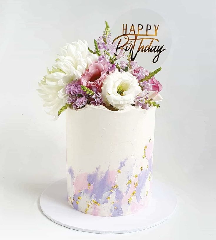 a birthday cake decorated with flowers and the words happy birthday on it's top