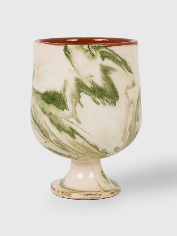 a white and green marbled cup with brown rim