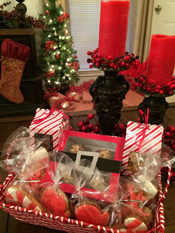 a basket filled with cookies and candies on top of a table next to a christmas tree