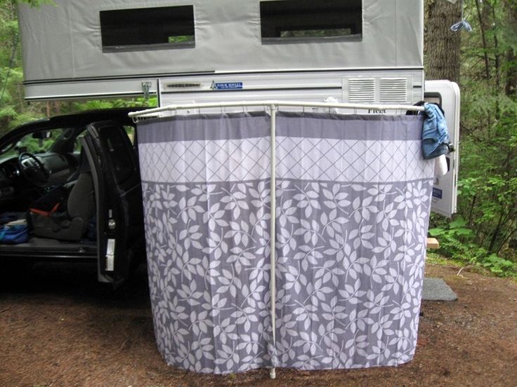 the back door of a car with a tent attached to it's side and trees in the background