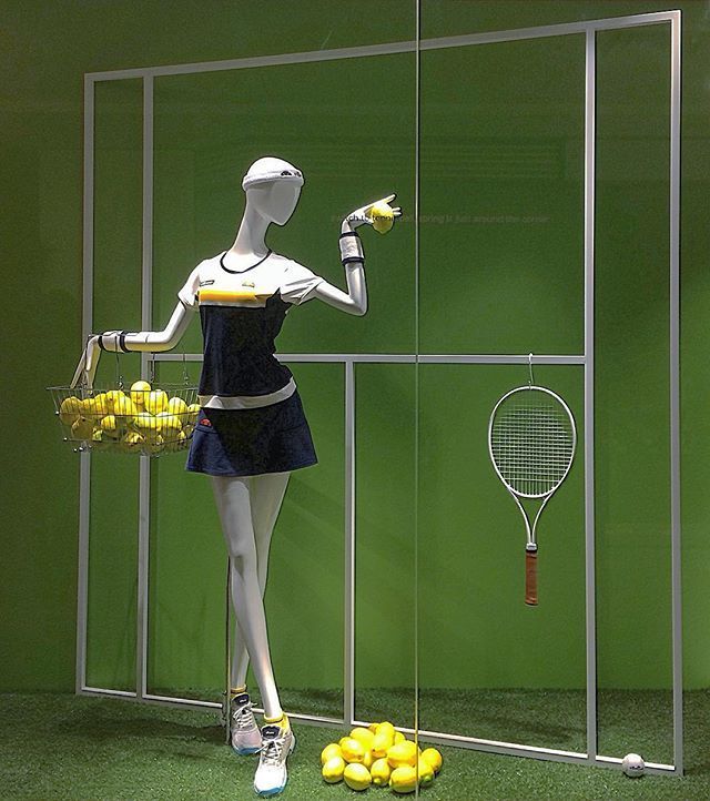 a mannequin with tennis rackets and baskets of lemons