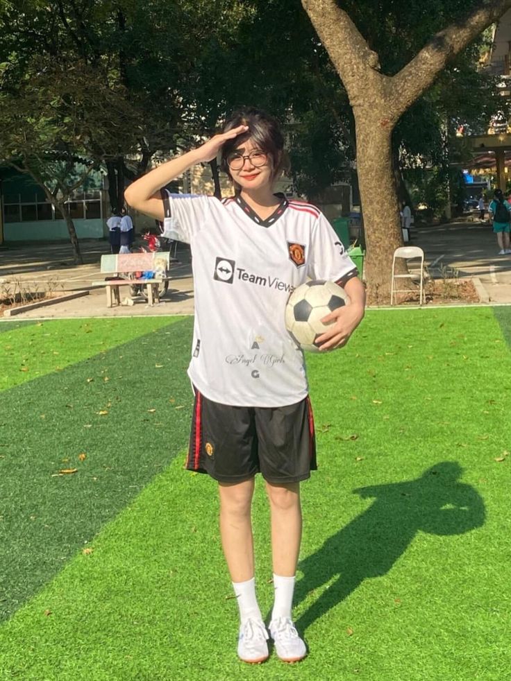 a person standing in the grass with a soccer ball