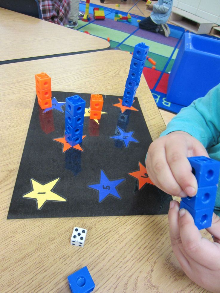 a child is playing with plastic blocks and magnets on the table in front of them