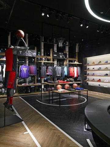 the inside of a sports shop with basketballs and shirts on display in front of them