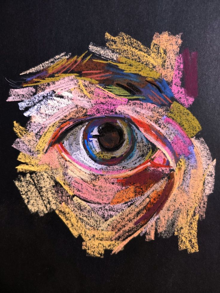 an eye made out of colored crayons on black paper