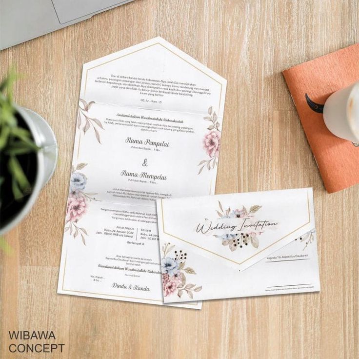 the wedding stationery is laid out on top of the wooden table next to a cup of coffee