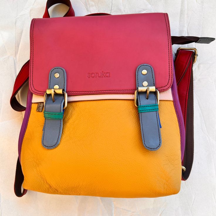 front of Sunrise freya backpack. Leather Flap Backpack With Adjustable Strap For On-the-go, Versatile Flap Backpack For Everyday Use, Travel Backpack With Removable Pouch And Flap, Versatile Backpack With Adjustable Straps For Back To School, Backpack With Adjustable Straps For Back To School, Multicolor Backpack With Removable Pouch, On-the-go Leather Backpack With Adjustable Straps, Multicolor Standard Backpack With Removable Pouch, Backpack With Detachable Strap