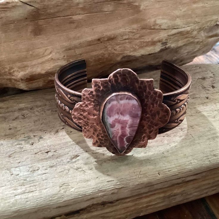 I Designed And Hand Crafted This Genuine Copper And Rhodonite Cuff Bracelet. The Copper Surrounding The Rhodonite Is Hand Hammered. The Inside Of The Cuff Is Stamped With My Maker's Mark. Truly A Unique Design, Slightly Oxidized To Help The Stampings And Hammerings To Shine Through. The Cuff Measures 6 X 3/4 Inches. The Piece With The Stone Measures 1.5 X 1.5 Inches. This Piece Comes Gift Boxed And Also Includes My Studios Business Card With My Contact Information. Unique Adjustable Pink Cuff Bracelet, Artisan Pink Gemstone Jewelry, Pink Hand-wrapped Bangle Jewelry, Hand Wrapped Pink Bangle Jewelry, Pink Hand Wrapped Bangle Jewelry, Bohemian Pink Cuff Bracelet As Gift, Pink Spiritual Bangle, Unique Hand Wrapped Pink Jewelry, Bohemian Hand Wrapped Pink Jewelry