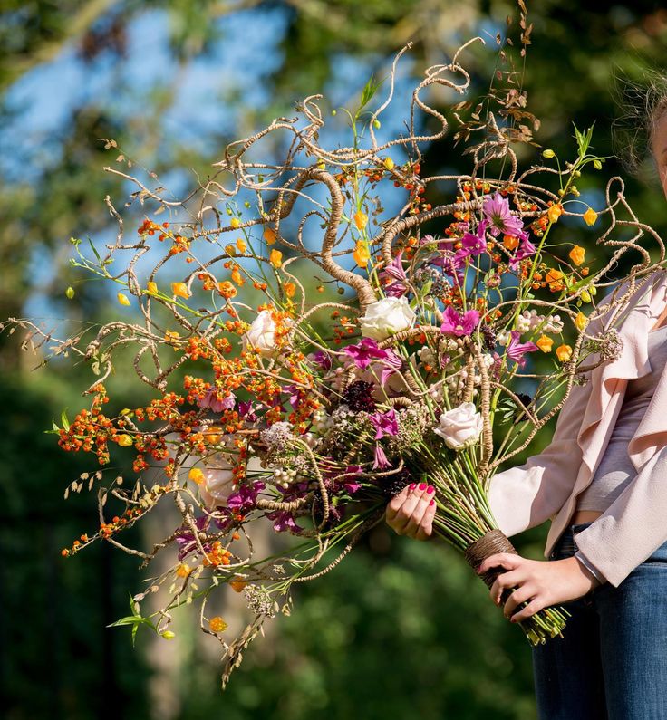 a woman holding a bouquet of flowers in her hands