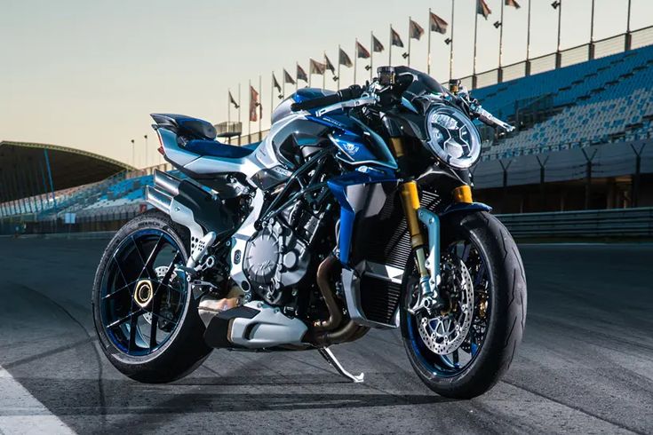 a blue and silver motorcycle parked on top of a race track