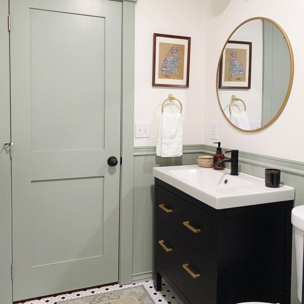 a white toilet sitting next to a bathroom sink under a mirror on top of a wooden cabinet