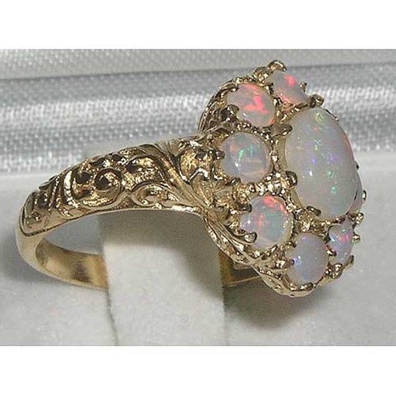 *This ring is made from 375 9K (9ct 9Kt) Yellow Gold with Genuine Natural Semi-precious Opals.A beautiful Opal & Garnet Ring set with a center 7x5mm (0.28"x0.20") & eight 3.25mm (0.13" inches) colorful Opals in a stylish Victorian Style cluster prong setting in solid 9K Yellow Gold. *Height 5mm, Width 15mm, Length 15mmLike all my jewelry pieces, this ring is made in my own workshop.PLEASE MAKE SURE YOU STATE THE FINGER SIZE YOU REQUIRE WITH YOUR PAYMENT AND ALSO INCLUDE YOUR TELEPHONE NUMBER FOR Victorian Opal Ring, Exquisite 14k Gold Cluster Ring, Classic 14k Gold Flower Ring With Gemstone, Heirloom 14k Gold Flower Ring With Gemstone, Gold Opal Ring With 17 Jewels, Exquisite Yellow Gold Opal Ring For Anniversary, Luxury 14k Gold Opal Ring For Anniversary, Exquisite Yellow Gold Opal Anniversary Ring, Elegant Multi-stone Cluster Opal Ring