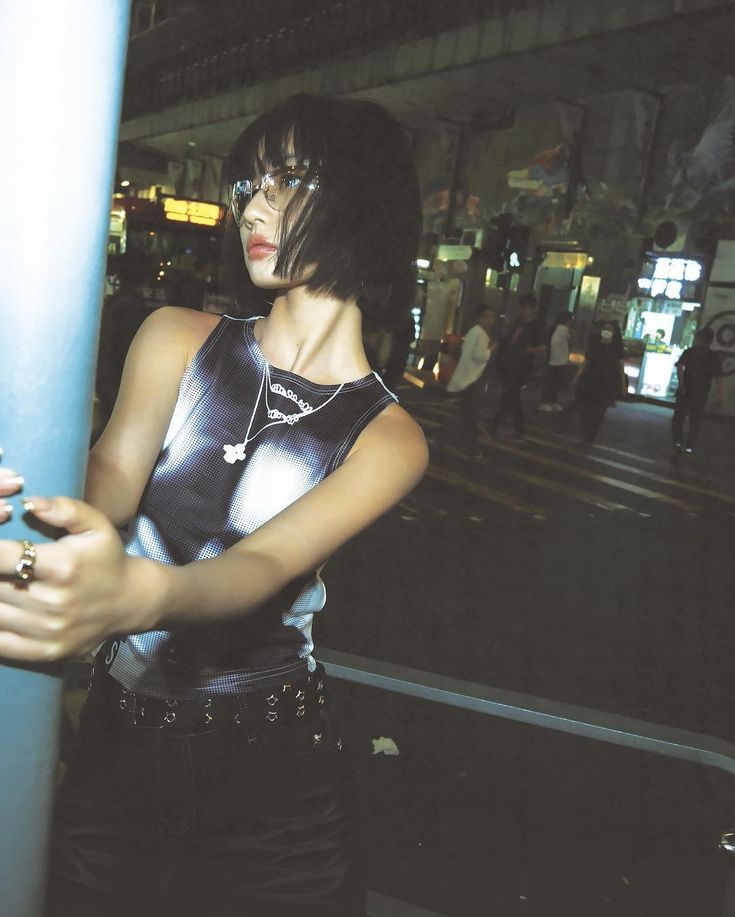 a woman standing next to a blue pole