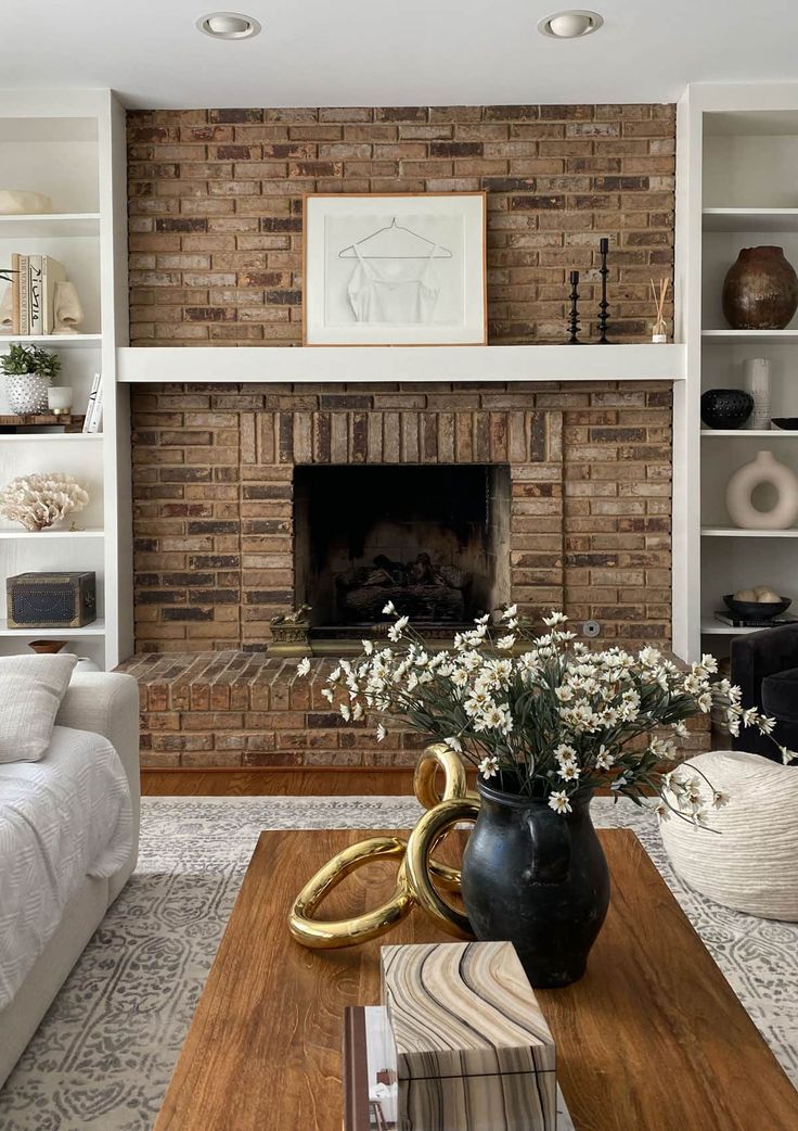 a living room filled with furniture and a fire place in front of a brick fireplace