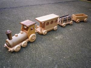 a wooden toy train is shown on the ground next to another toy car that has been made out of wood