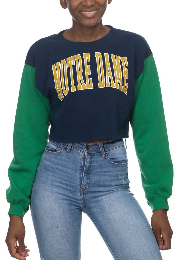 Make your way to the big game in this Notre Dame Fighting IrishWomens White Crop Colorblock Sleeve Crew Sweatshirt! This Fighting Irish Long Sleeve Sweatshirt features a screen print team name on center chest. Stay warm and comfortable with this Womens Fighting Irish Fighting Irish Crew Sweatshirt. Trendy Green Spliced Top, Trendy Green Top With Splicing Detail, Green Tops With Contrast Color For Fall, Green Contrast Color Tops For Fall, Sporty Color Block Winter Tops, Sporty Color Block Tops For Winter, College Blue Color Block Sweatshirt, Casual Color Block Tops For Sports Season, Sporty Contrast Color Tops For Fall