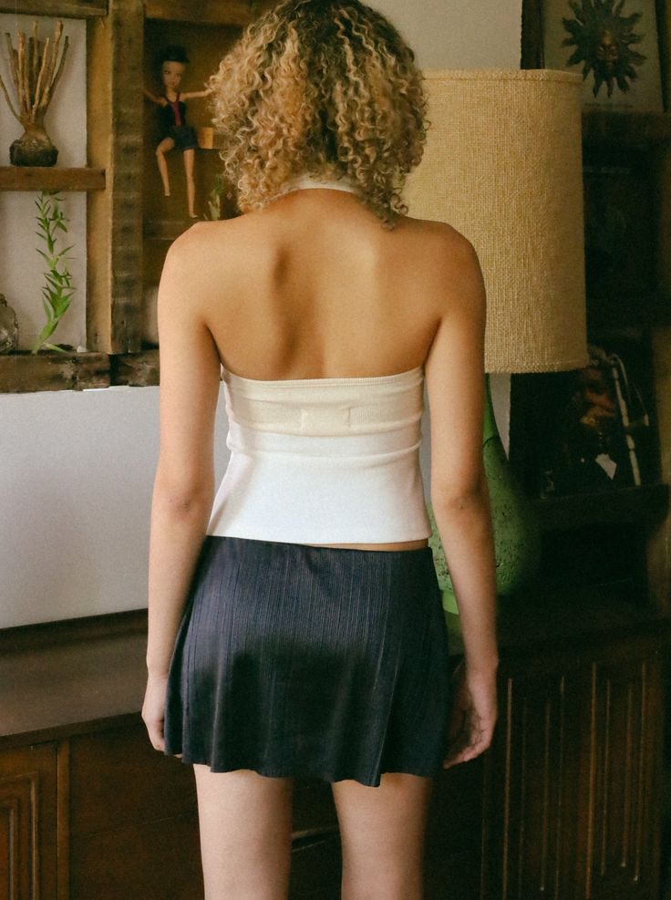 Crafted from a unique, high-quality fabric, it offers a stay-put fit that won't cling to your skin while still shaping your figure. The cinched waist and flared bottom create a beautiful hourglass silhouette. A snug, secure fit around the bust. Wear the attached rib bandeau in front to make a statement or reverse it for a more classic halter look. Nine adjustable snap buttons at the bust ensure a perfect fit. *ivory halter fabric has a subtle diagonal texture to minimize any show through when wo Fitted Beige Tops With Built-in Bra, Fitted Halter Top With Built-in Bra, Fitted Beige Ruched Top, Fitted Beige Top With Built-in Bra, Chic White Fitted Halter Top, Fitted Beige Top For Night Out, Fitted Sleeveless Cream Top, Cream Sleeveless Fitted Top, Cream Fitted Sleeveless Top