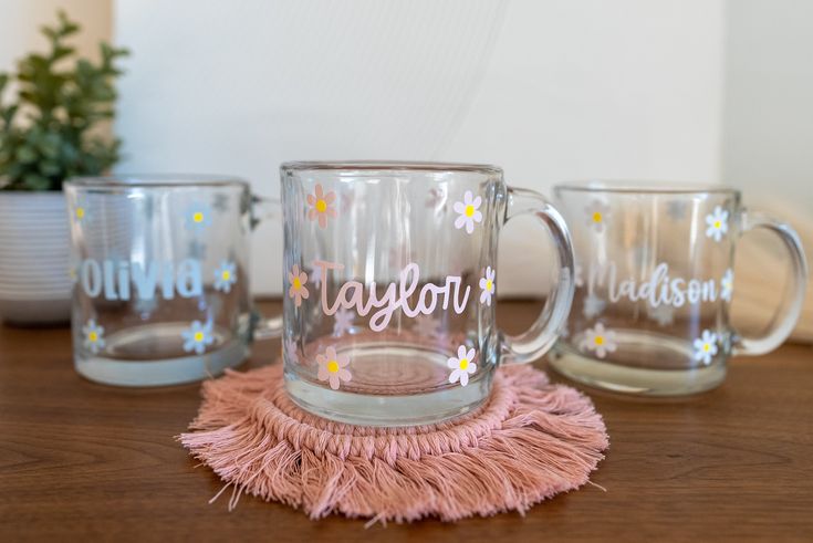 three glass mugs sitting on top of a wooden table