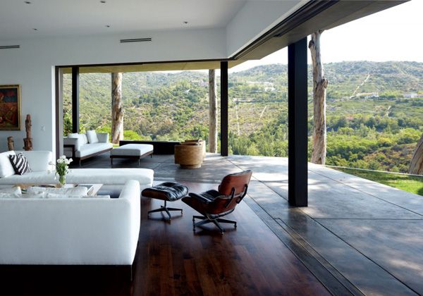 a living room with wooden floors and white furniture on the top floor, overlooking mountains