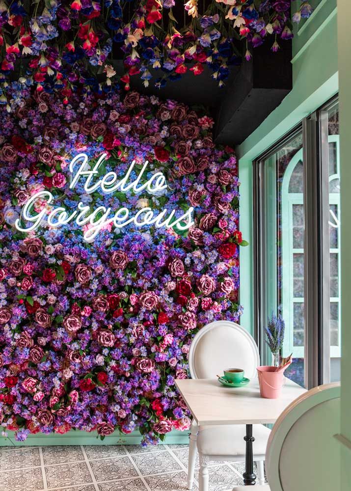 the inside of a restaurant with flowers on the wall and tables in front of it