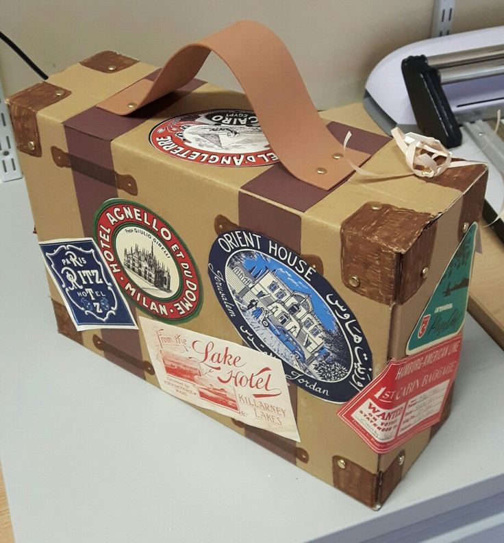 a brown suitcase with stickers on it sitting on a desk