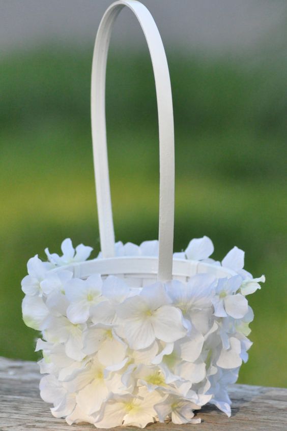 a white flower basket sitting on top of a wooden table