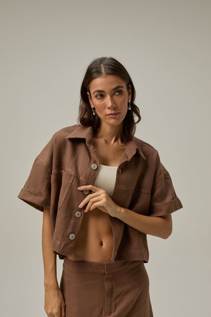 Introducing our linen cropped shirt, a standout piece that exudes style and charm. With its slightly oversized cut, this shirt offers a relaxed and modern silhouette that flatters any body type. Whether you pair it with your favorite jeans for a casual yet chic look or combine it with other light linen pieces for a coordinated ensemble, this shirt effortlessly enhances your outfit. COMPOSITION AND CARE Material: 100% linen - Washed linen Linen is one of the most sophisticated natural fiber fabri Trendy Collared Linen Shirt, Trendy Cropped Shirt For Spring, Casual Relaxed Fit Cropped Shirt, Chic Cropped Linen Tops, Trendy Linen Tops For Everyday, Brown Linen Relaxed Fit Tops, Brown Relaxed Fit Linen Top, Versatile Cropped Linen Tops, Relaxed Fit Cropped Shirt