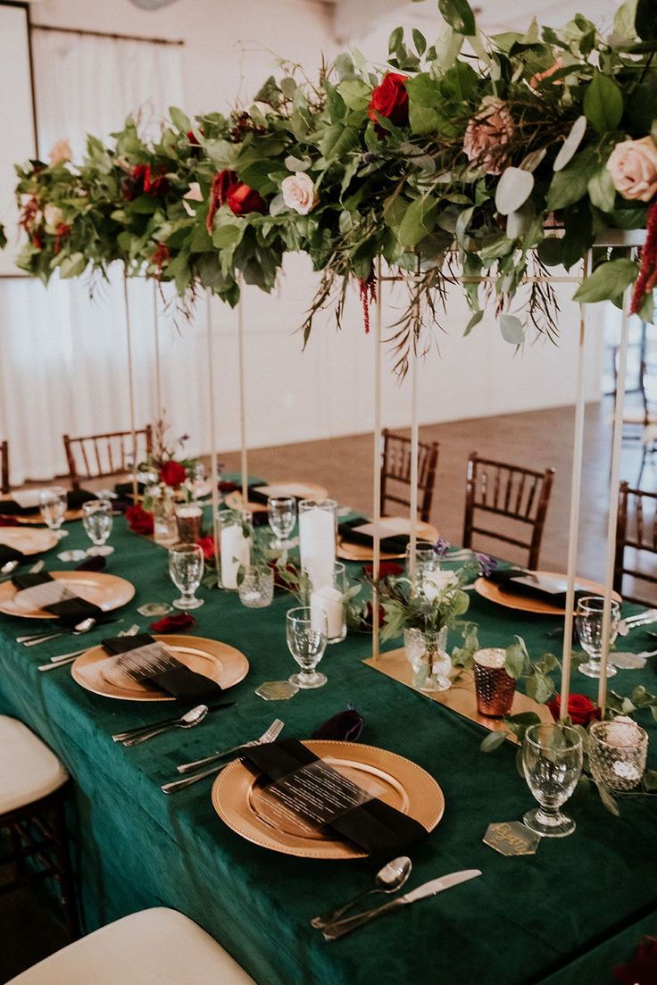 a table set with place settings and flowers on the centerpieces for an elegant wedding reception