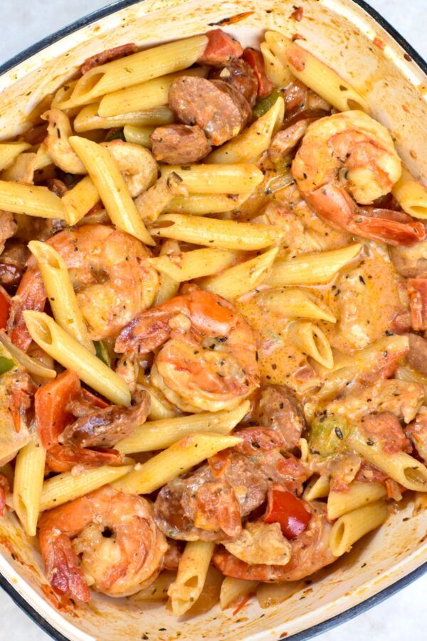 pasta with shrimp, tomatoes and sausage in a skillet ready to be served on the table