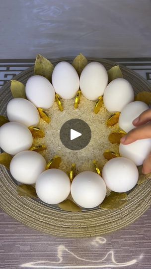 someone is placing eggs in the center of a bowl with gold trimmings on it