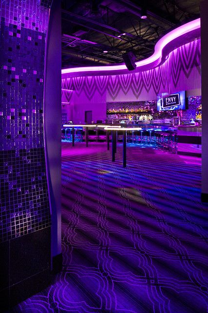 an empty room with purple lighting and disco lights on the ceiling is pictured in this image